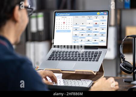 Man Using Agenda Calendar Schedule App On Laptop Computer Stock Photo