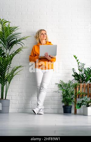 Woman girl using computer laptop working office work remotely from home. urban jungle home plants. Distance learning online education and work Stock Photo