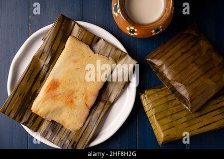 Prehispanic dish typical of Mexico and some Latin American countries. Corn dough wrapped in banana leaves. The tamales are steamed. Stock Photo