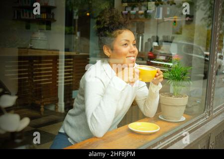 Portrait of a woman looking through a window in a cafe . High quality photo Stock Photo