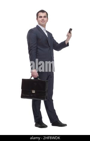 handsome young business man talking on a mobile phone and holding a suitcase on white background Stock Photo