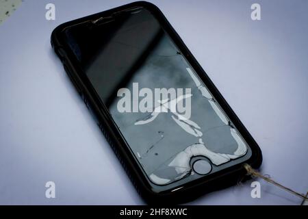 Broken phone screen with glass protector and string attached Stock Photo