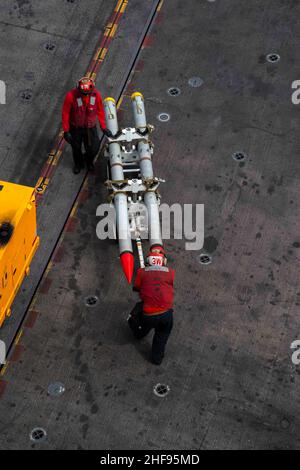 220114-N-PV401-1176 SOUTH CHINA SEA (Jan. 14, 2022) Sailors transport ordnance on the flight deck of Nimitz-class aircraft carrier USS Carl Vinson (CVN 70), Jan. 14, 2022. Carl Vinson Carrier Strike Group is on a scheduled deployment in the U.S. 7th Fleet area of operations to enhance interoperability through alliances and partnerships while serving as a ready-response force in support of a free and open Indo-Pacific region. (U.S. Navy photo by Mass Communication Specialist Seaman Elizabeth Grubbs) Stock Photo