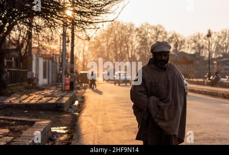 Srinagar, India. 11th Jan, 2022. A man looks on as he walks along the road during sunset. Credit: SOPA Images Limited/Alamy Live News Stock Photo