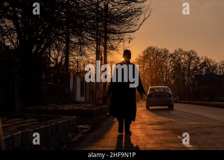 Srinagar, India. 11th Jan, 2022. A silhouette of a man walking along the road during sunset. Credit: SOPA Images Limited/Alamy Live News Stock Photo