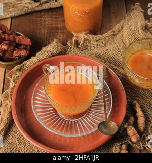 Jamu Kunyit Asam, Traditional Indonesian Herbal Tonic Drink. Made from Turmeric, Tamarind, and Palm Sugar. Usually Served To Boost Imune Stock Photo