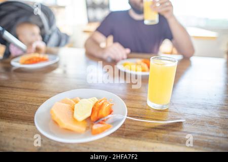 Delicious fruit slices and orange juice on wooden table with blurry background Stock Photo