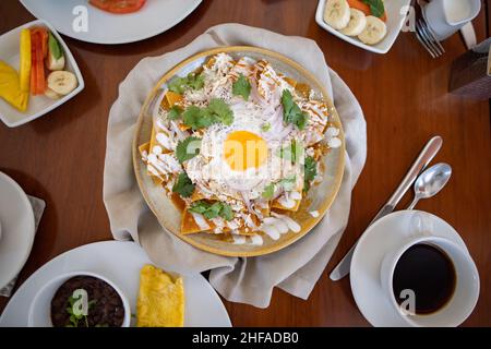 Delicious chilaquiles and more dishes on brown table Stock Photo