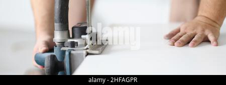 Male hands working with an electric plane close-up Stock Photo