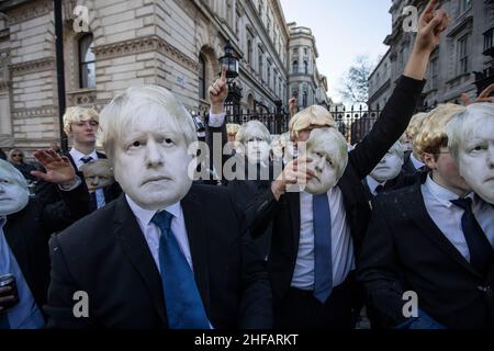 Flash-mob of 'partygate' anti-Boris Johnson protesters wearing floppy blond wigs and Boris Johnson Stock Photo