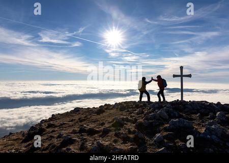 Mother and son giving high five on the top of Kucelj mountain, Slovenia Stock Photo