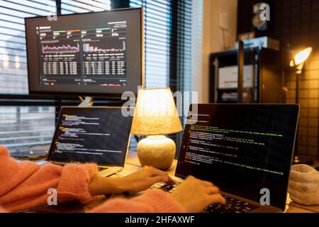 Female programmer writing programming code at cozy home workplace Stock Photo