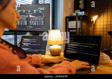 Female programmer writing programming code at cozy home workplace Stock Photo