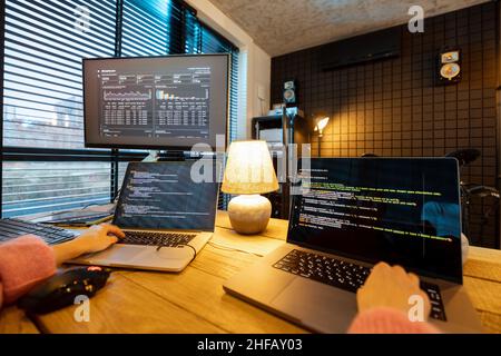 Female programmer writing programming code at cozy home workplace Stock Photo