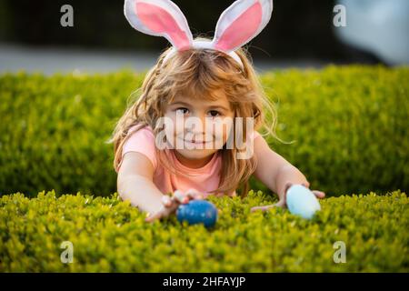 Kids boy hunting easter eggs. Happy easter bunny child boy. Spring kids holidays concept. Funny kids face closeup. Stock Photo