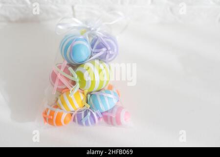multi-colored chicken eggs in bag mesh on white background. easter Stock Photo