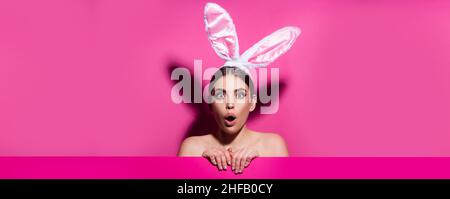 Easter banner with bunny woman. Funny emotions, excited expressing. Bunny woman isolated on pink. Stock Photo