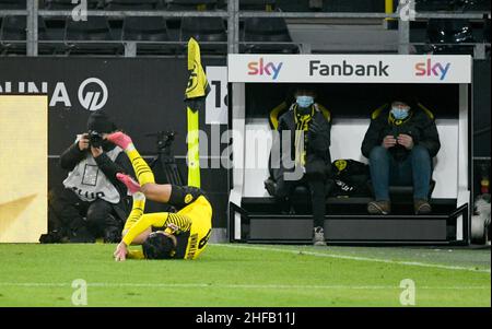 Signal Iduna Park Dortmund, Germany, 14.1.2022, Football: Bundesliga Season 2021/22, matchday 19, Borussia Dortmund (BVB) vs SC Freiburg (SCF) - Mahmoud Dahoud (BVB) rolls over in celebration in front of the BVB team photographer and two fans on a sponsor’s fan bank  DFL REGULATIONS PROHIBIT ANY USE OF PHOTOGRAPHS AS IMAGE SEQUENCES AND/OR QUASI-VIDEO Stock Photo
