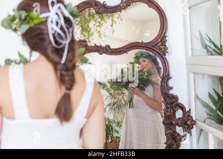 Beautiful pregnant woman at the mirror indoor Stock Photo