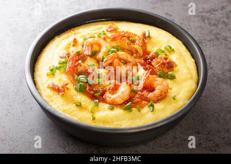 Delicious yellow grits with cheese, shrimps and bacon close-up in a plate on the table. horizontal Stock Photo