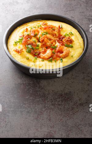 Plate with fresh tasty shrimp and grits closeup on the concrete table. Vertical Stock Photo