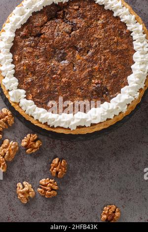 Chocolate Walnut Pie is made with brown sugar, corn syrup and a hint of bourbon closeup in the concrete table. Vertical top view from above Stock Photo