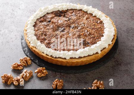 Fresh dark Chocolate Chip Walnut Pie closeup on the concrete table. Horizontal Stock Photo