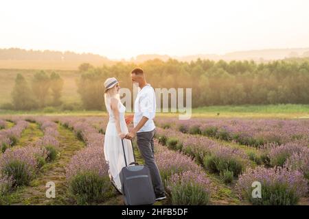 man and woman with travel suitcase in lavender field, Stock Photo