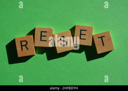 Reset, word in wooden alphabet letters isolated on bright green background Stock Photo