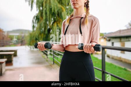 Young woman training with dumbbells Stock Photo