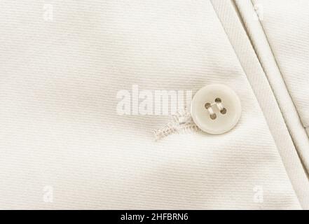 Button on white clothes. Element of men's clothing. Trousers Stock Photo