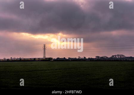 Looking across an arable farm at sunrise in West Sussex Stock Photo