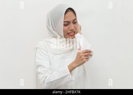 Close up muslim woman having pain in injured elbow hand isolated on white background Stock Photo