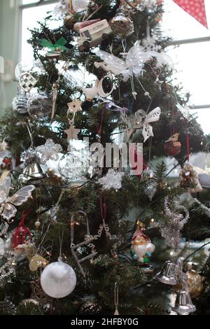 Artificial christmas tree with white, silver and red decorations Stock Photo