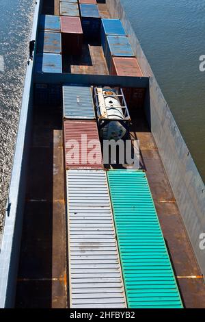 ship on river transports container in belly Stock Photo