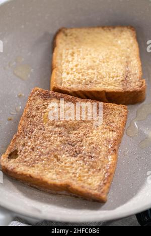 Frying french toast in a nonstick frying pan. Stock Photo