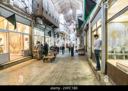 Traders in a corridor of the Carpet Bazaar in the Grand Bazaar in Tehran, Iran Stock Photo