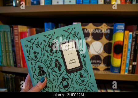 Portugal, Europe - 18th November 2019 - Women holding a book in a book store, shop, Charles Dickens. Title Great Expectations. Famous British author Stock Photo