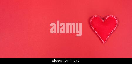Heart on a red plain background. Valentine's day promotion long banner with copy space. Valentine's day concept background for postcard, sale banner, Stock Photo