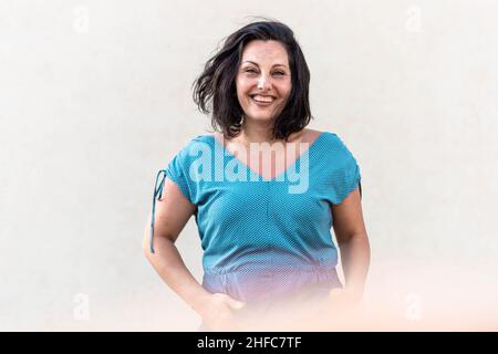 Middle age confident, brunette woman standing and smiling Stock Photo