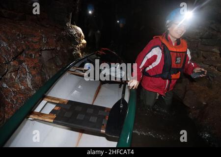 15 January 2022, Saxony-Anhalt, Wettelrode: Visitors take part in a canoe tour in the Röhrigschacht. 283 meters underground in the Röhrigschacht, visitors can not only ride the mine train and take a look on foot at how copper ore used to be mined in the Sangerhausen and Mansfeld mining districts. From now on, deep down in the mountain after the Corona loosenings, canoeing is also possible again. The canoeing fun at 1,800 meters takes visitors down a route that is about 135 years old and branches off from the normal museum area. Participants travel a total of around 1,800 meters on the special Stock Photo