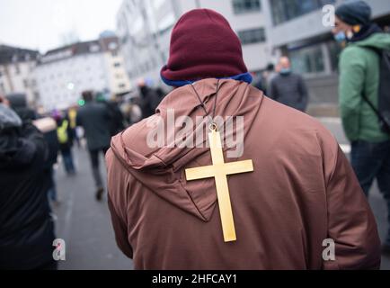 Frankfurt, Germany. 15th Jan, 2022. 15 January 2022, Hessen, Frankfurt/Main: Opponents of the current Corona measures demonstrate in downtown Frankfurt am Main, one man wearing a cross on his back. The police accompanied the action with a massive force. Photo: Boris Roessler/dpa Credit: dpa picture alliance/Alamy Live News Stock Photo