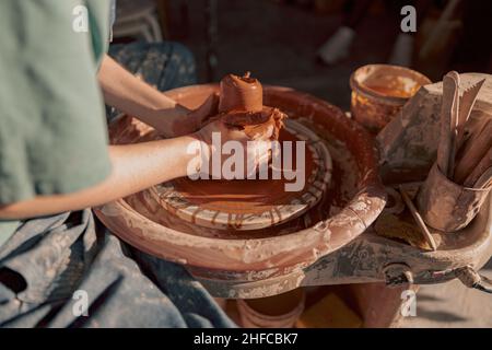 Clay artist modeling product on potter wheel in workshop Stock Photo