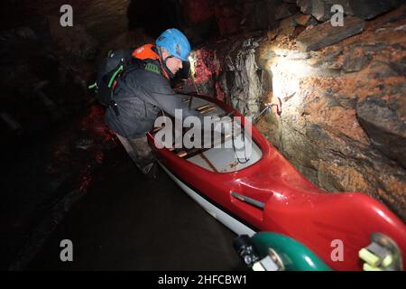 15 January 2022, Saxony-Anhalt, Wettelrode: Visitors take part in a canoe tour in the Röhrigschacht. 283 meters underground in the Röhrigschacht, visitors can not only ride the mine train and take a look on foot at how copper ore used to be mined in the Sangerhausen and Mansfeld mining districts. From now on, deep down in the mountain after the Corona loosenings, canoeing is also possible again. The canoeing fun at 1,800 meters takes visitors down a route that is about 135 years old and branches off from the normal museum area. Participants travel a total of around 1,800 meters on the special Stock Photo