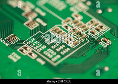 Many small electronic components soldered on green printed circuit board (PCB). Stock Photo