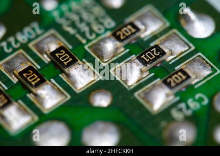 Multiple SMD resistors soldered on a green printed circuit board (PCB). Stock Photo