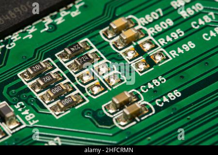 SMD resistors and capacitors soldered on a green printed circuit board (PCB). Stock Photo