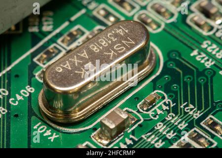 Crystal oscillator soldered on a green printed circuit board (PCB). Stock Photo