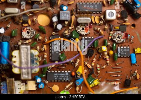 Old circuit board with many electronic components. Stock Photo