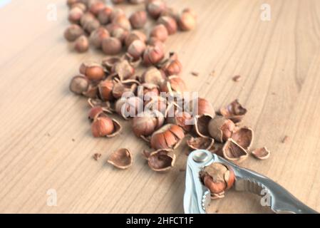 Broken hazelnuts with nutcracker on a table. Ready to eat nuts. Stock Photo
